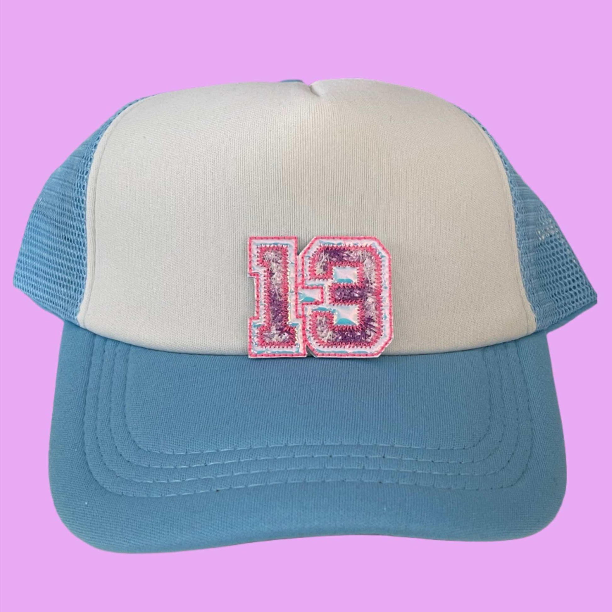 Taylor Swift Lucky 13 varsity style embroidered patch in pink and white, perfect for customizing clothing and accessories.