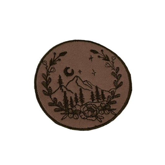 Mountain landscape embroidered patch with rustic moonlit scene and floral accents.