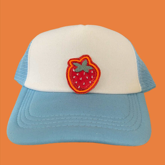 Close-up of a vibrant embroidered strawberry patch on a hat.