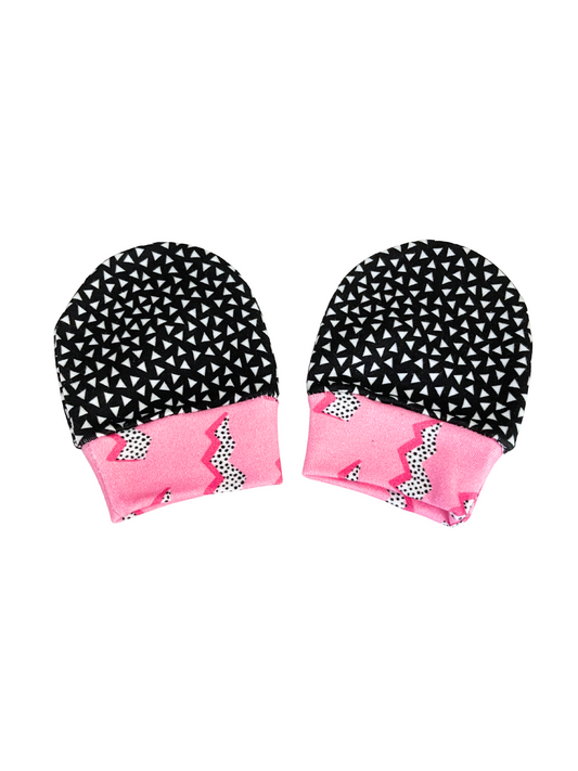 Organic cotton baby scratch mittens with black geometric and pink zigzag patterns.