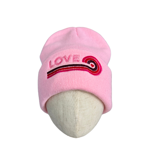 Adult pink "Love" beanie with retro embroidery and swirled pattern.
