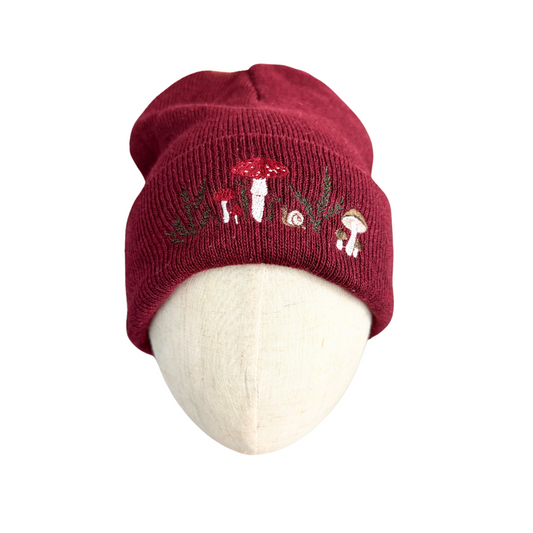 Adult mushroom forest beanie with embroidered mushroom and forest design in maroon.