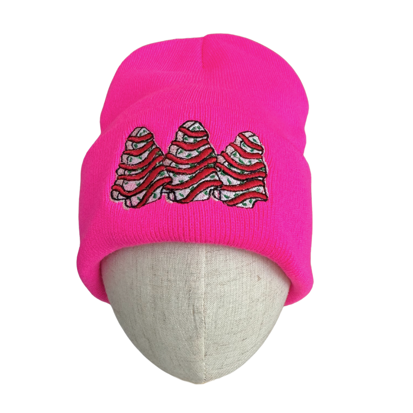 Bright pink beanie with Christmas tree snack cake embroidery, holiday cult favorite design.