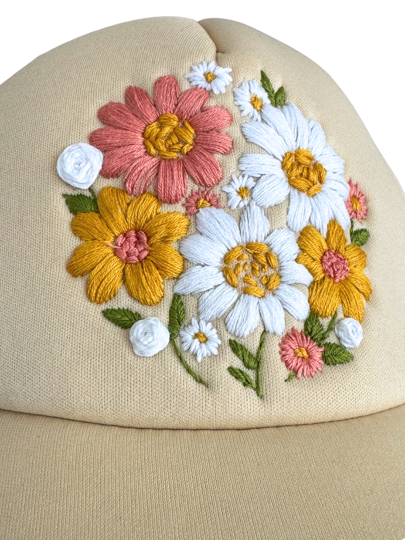 Hand-embroidered floral bouquet design on cream hat.

