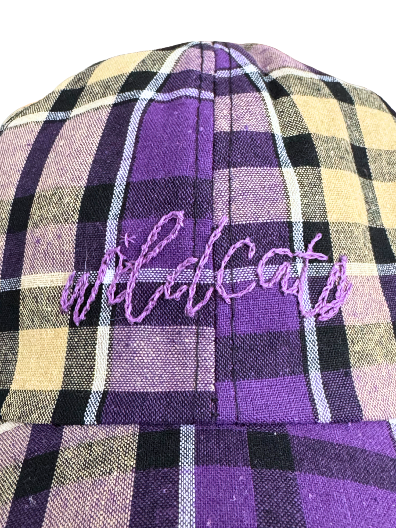 Hand-embroidered "Wildcats" design on purple and yellow plaid hat.


