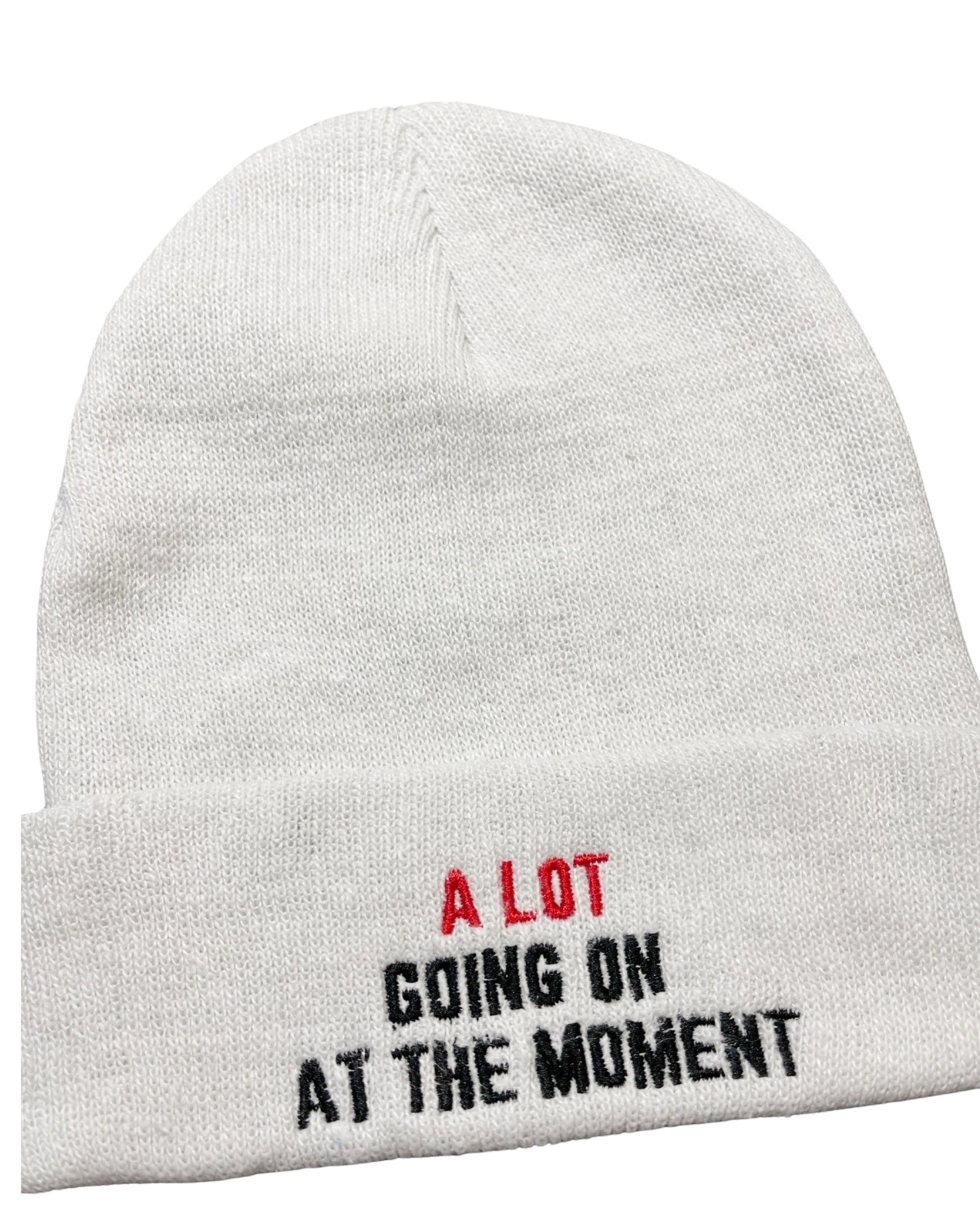 white knit beanie embroidered with "a lot going on at the moment" like the t shirt t swift wears on eras tour during the Red Era