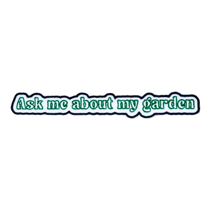 Flat lay of “Ask Me About My Garden” embroidered iron-on patch on white background

