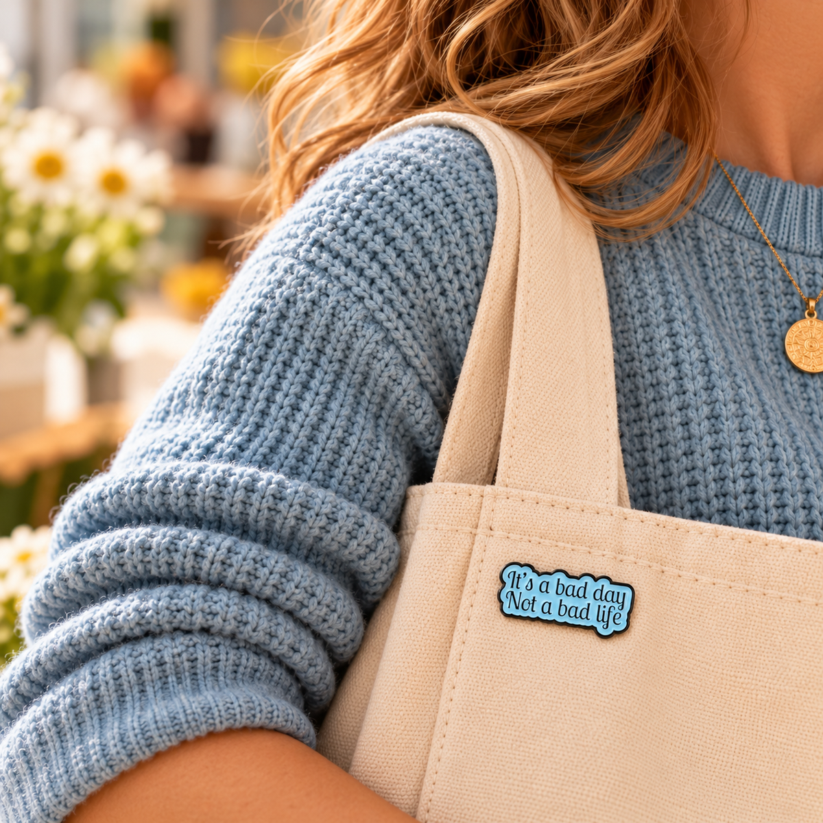 It's a Bad Day Not a Bad Life blue enamel pin styled on a cream canvas tote