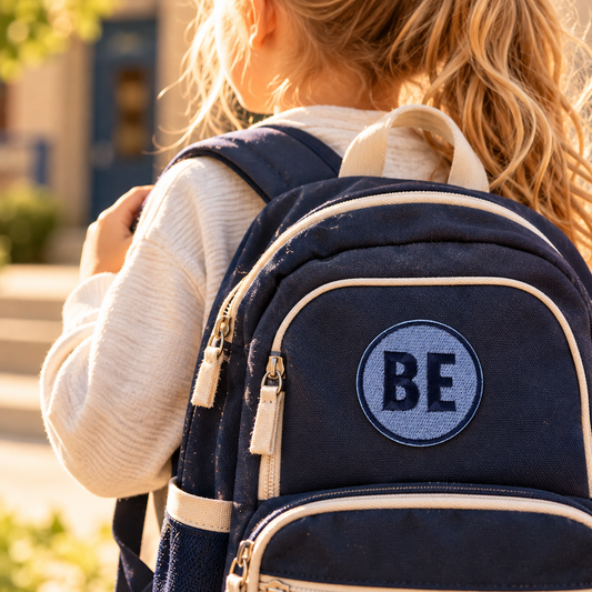 Belinder Elementary blue and navy BE embroidered patch on a navy school backpack