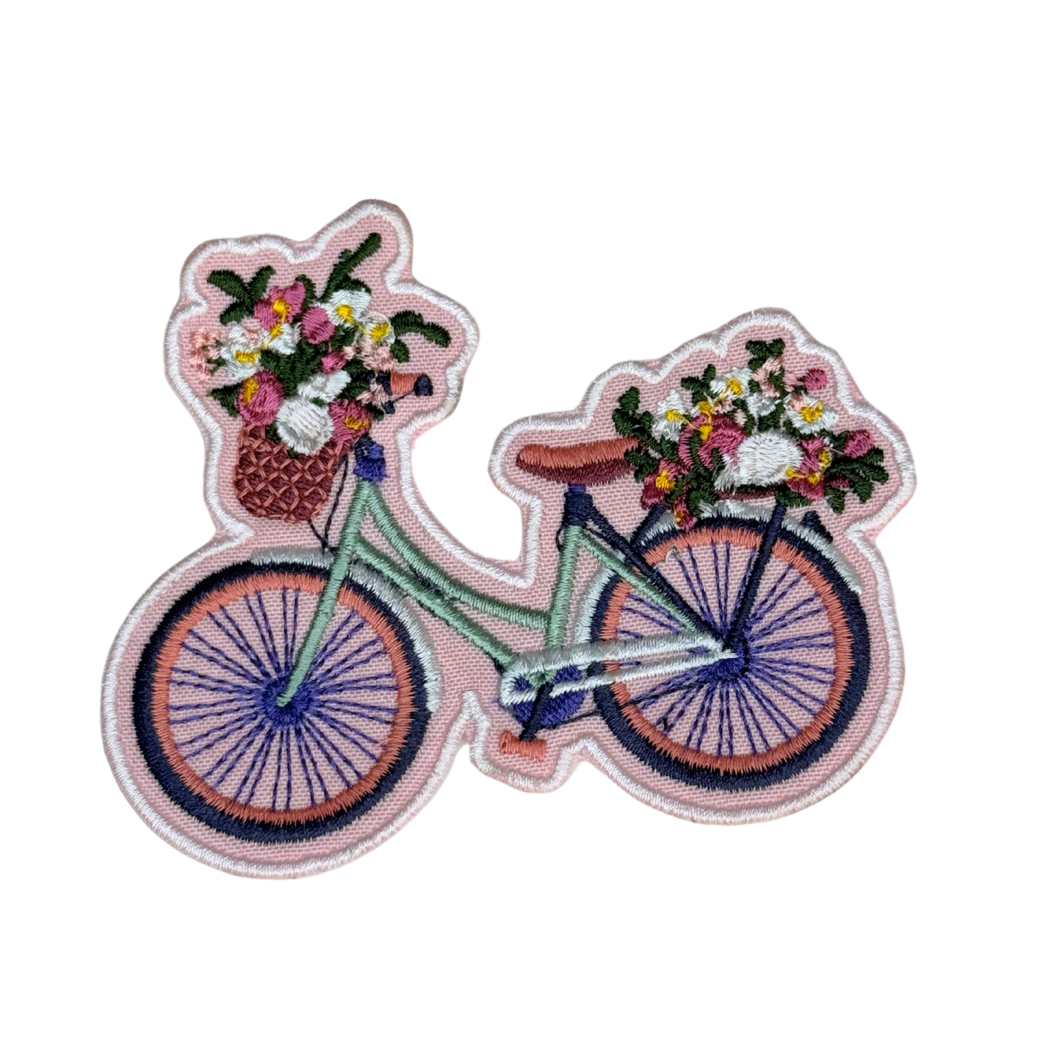 Flat lay of embroidered bicycle with flowers patch on white background
