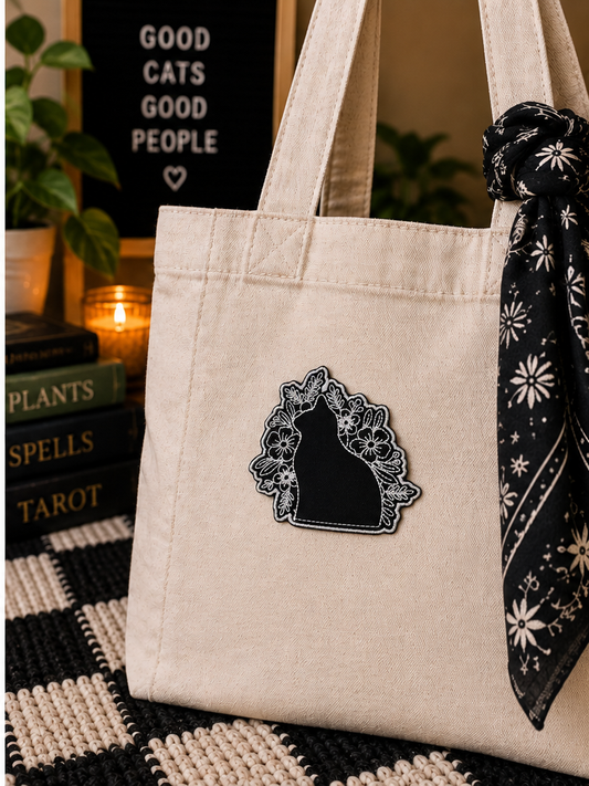 Black Cat Floral embroidered patch styled on a cream canvas tote