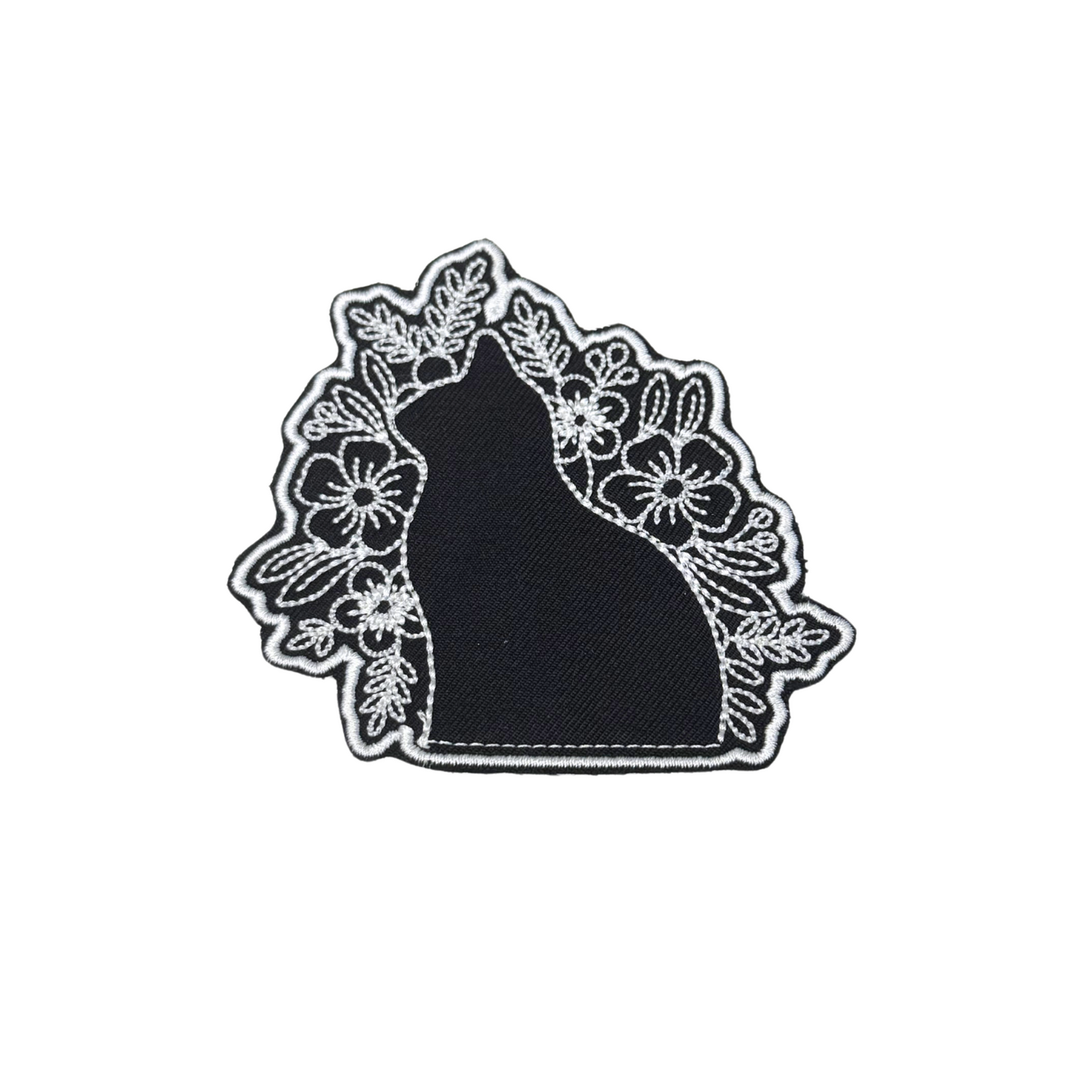 Black silhouette cat patch with floral white embroidery details
