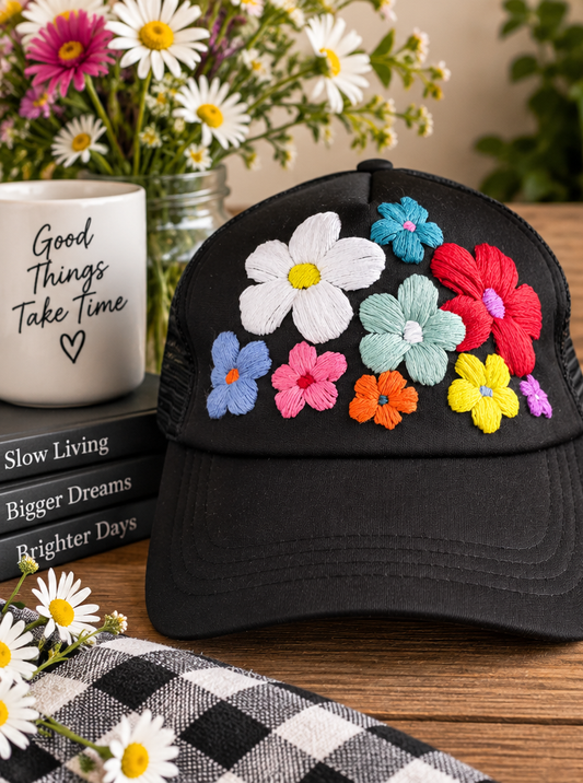 Black hand-embroidered floral trucker hat styled product photo
