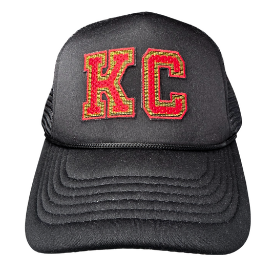 Front view of black trucker hat with red and gold varsity-style KC patch inspired by Kansas City Chiefs colors
