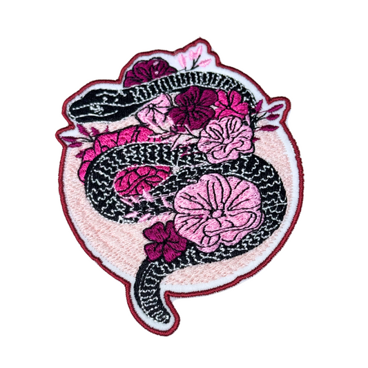 Black snake with pink flowers embroidered patch on white background

