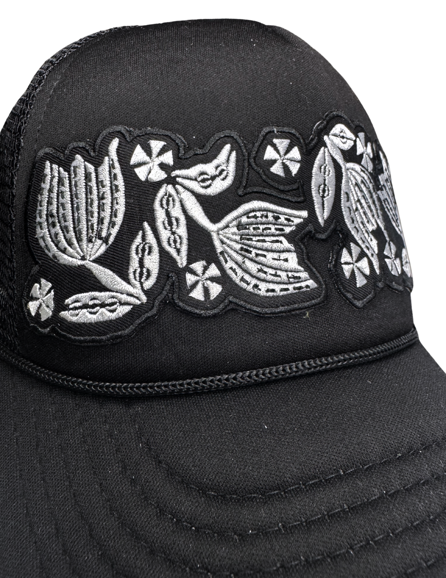 Detailed view of white-on-black floral patch referencing Pyrex Black Tulip pattern