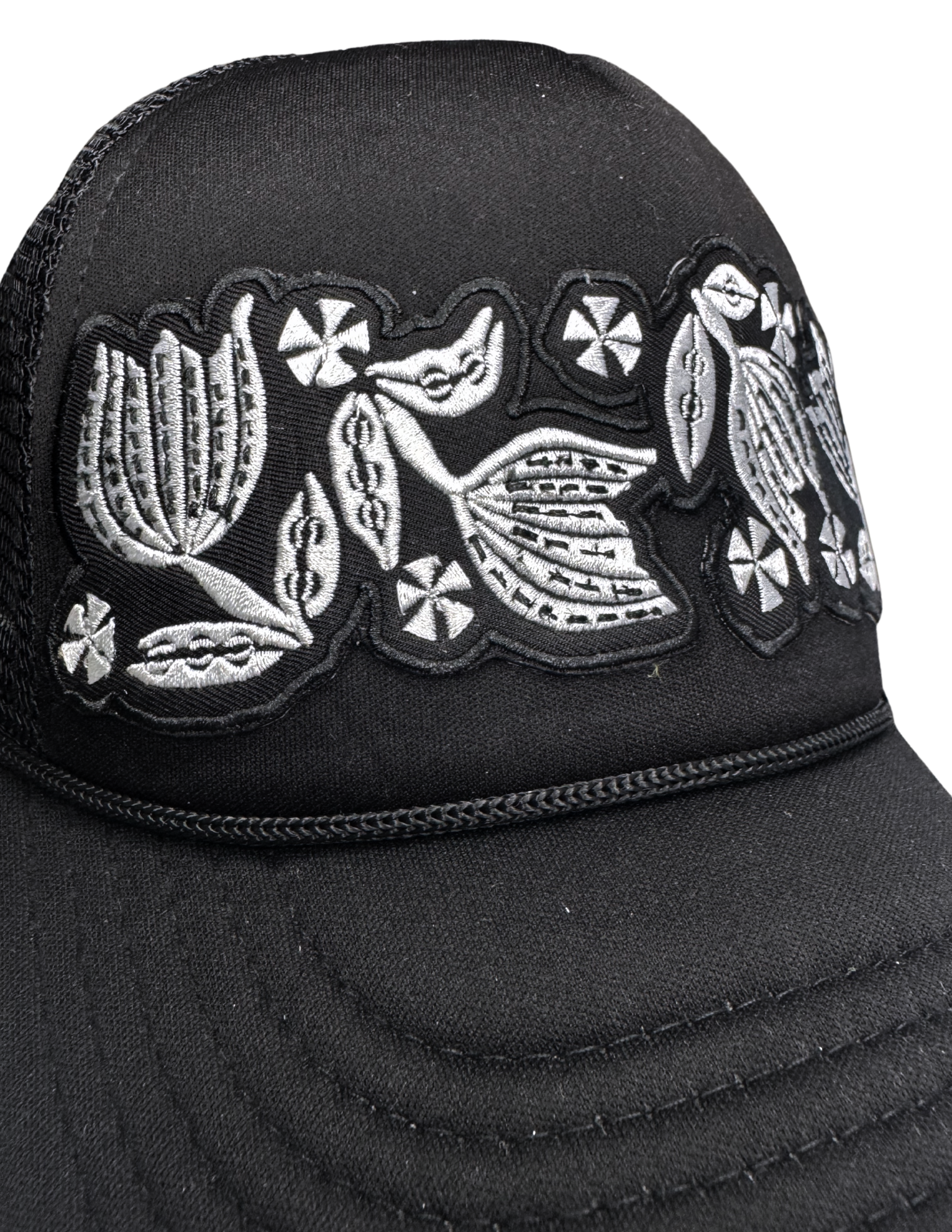 Detailed view of white-on-black floral patch referencing Pyrex Black Tulip pattern