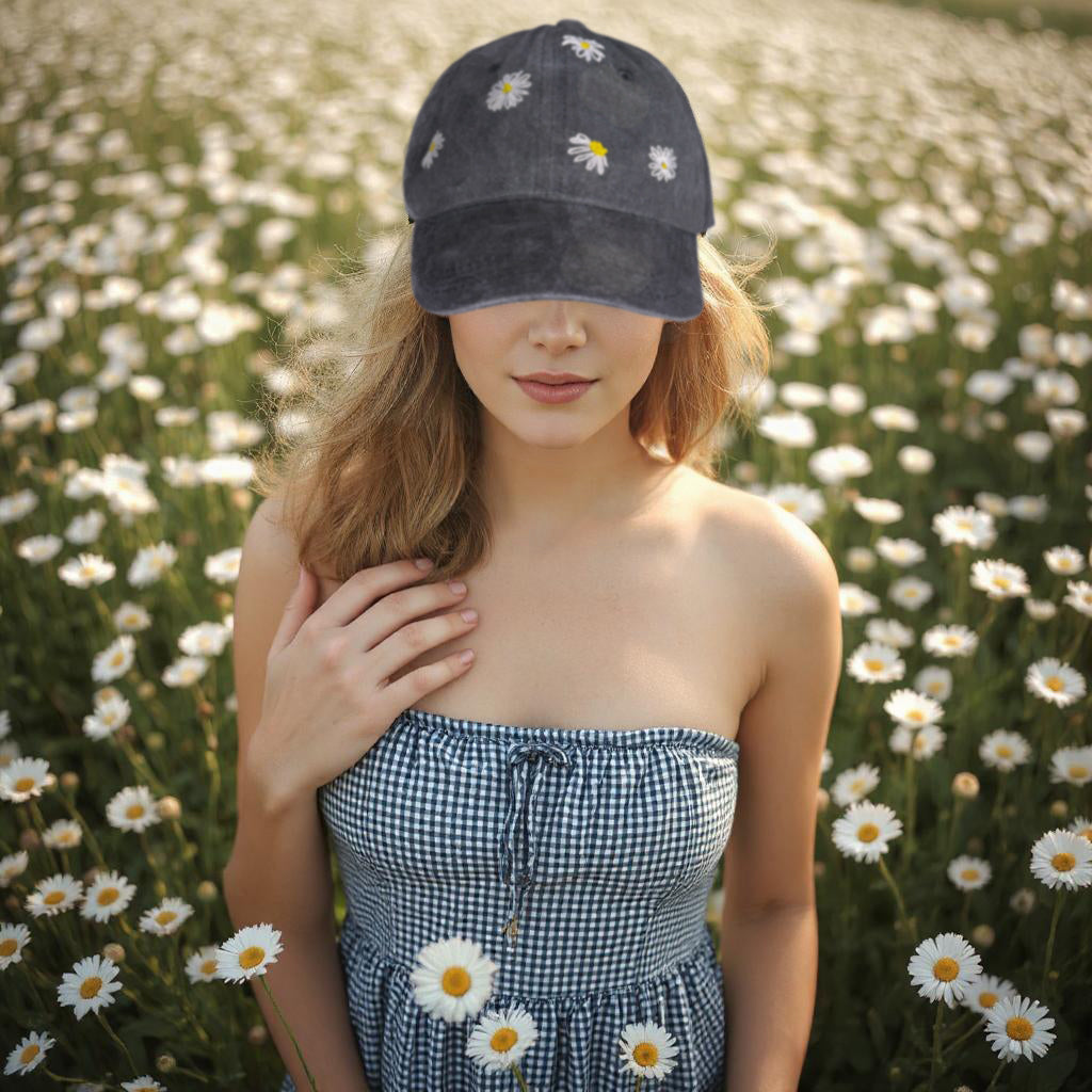 Woman wearing a dark gray cap and dress with floral patterns in a field of white flowers