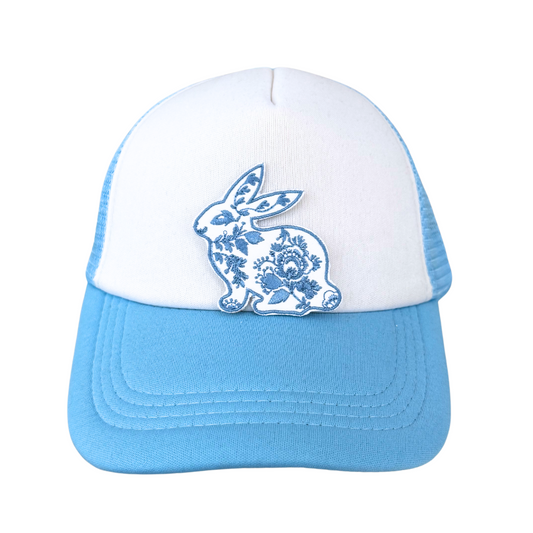 Blue and white floral bunny patch heat pressed onto a white and blue trucker hat
