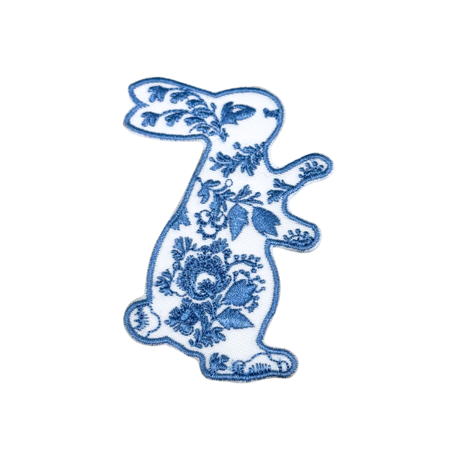 blue and white floral bunny embroidered patch standing upright on white background

