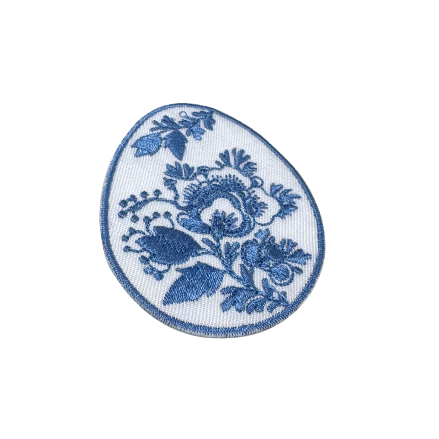 Close-up angled view of blue floral egg embroidery patch

