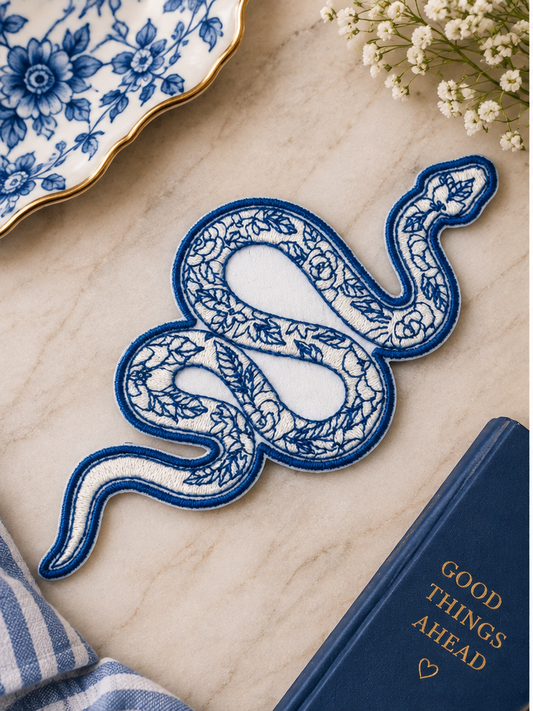 Blue Floral Snake embroidered iron-on patch styled with blue and white botanical accents