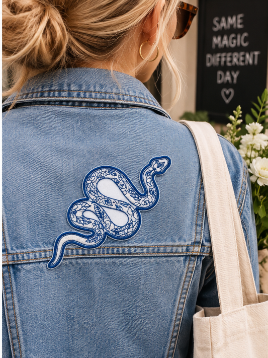 Blue Floral Snake embroidered patch worn on the back of a denim jacket