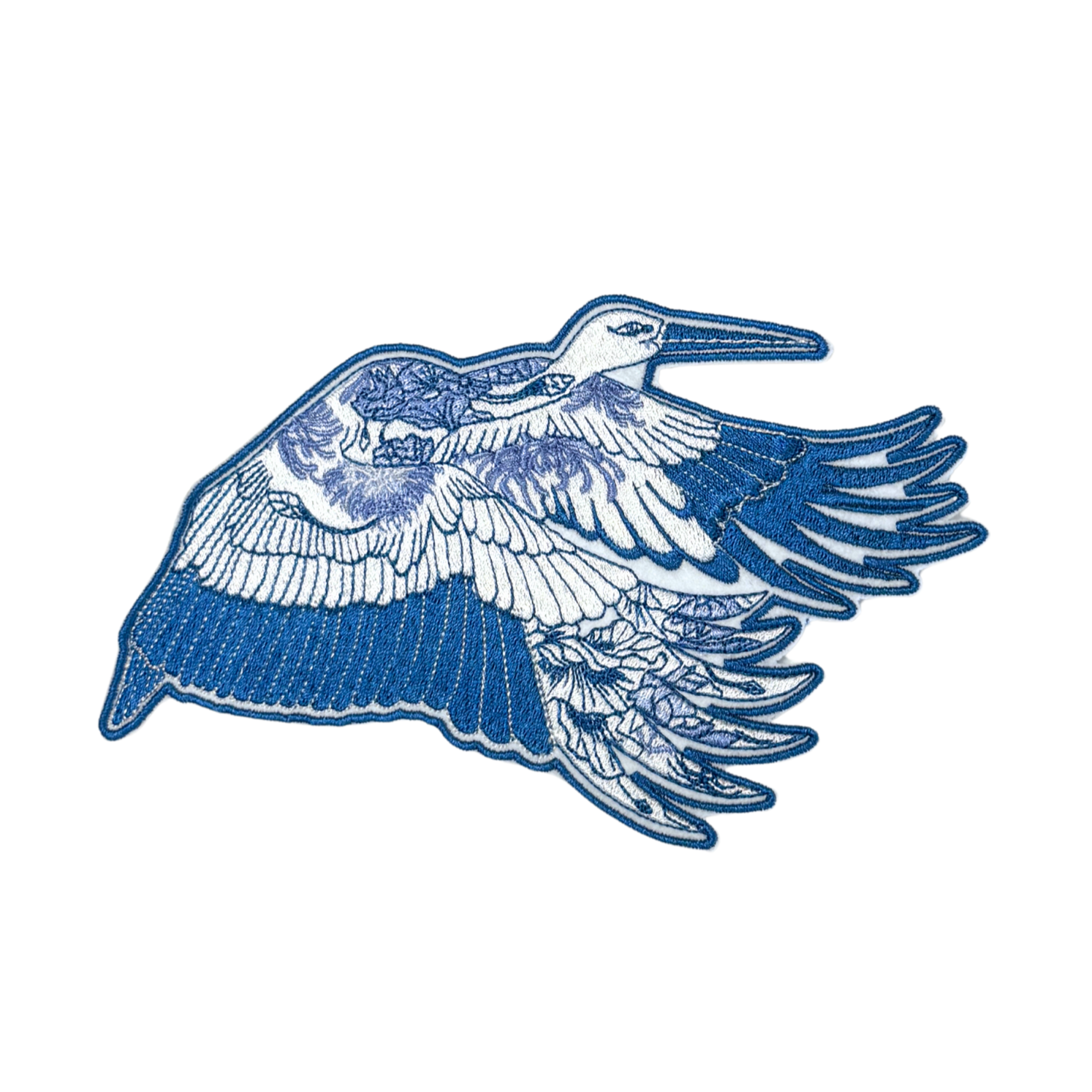 Close-up of a blue heron embroidered patch with intricate floral detailing.
