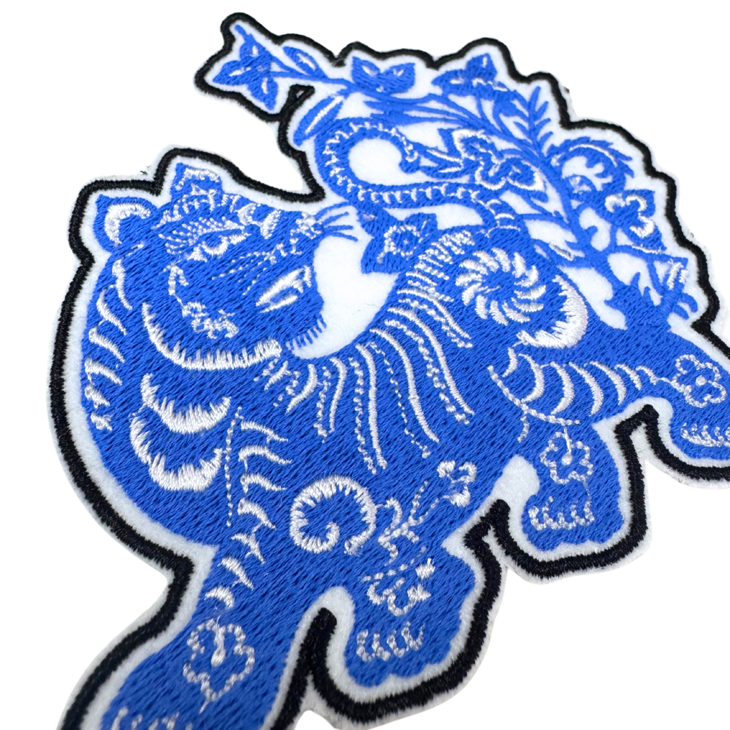 Detailed angle view of embroidered blue tiger patch highlighting fine craftsmanship.