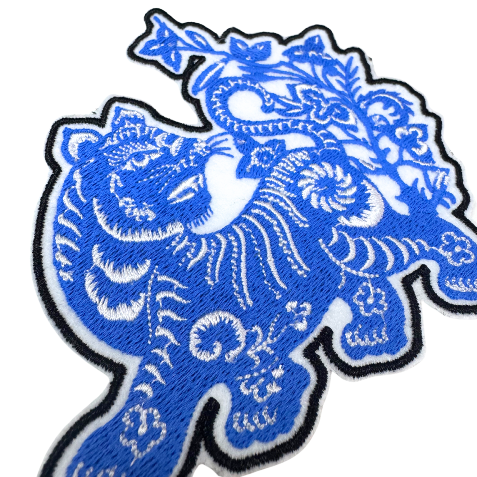 Detailed angle view of embroidered blue tiger patch highlighting fine craftsmanship.