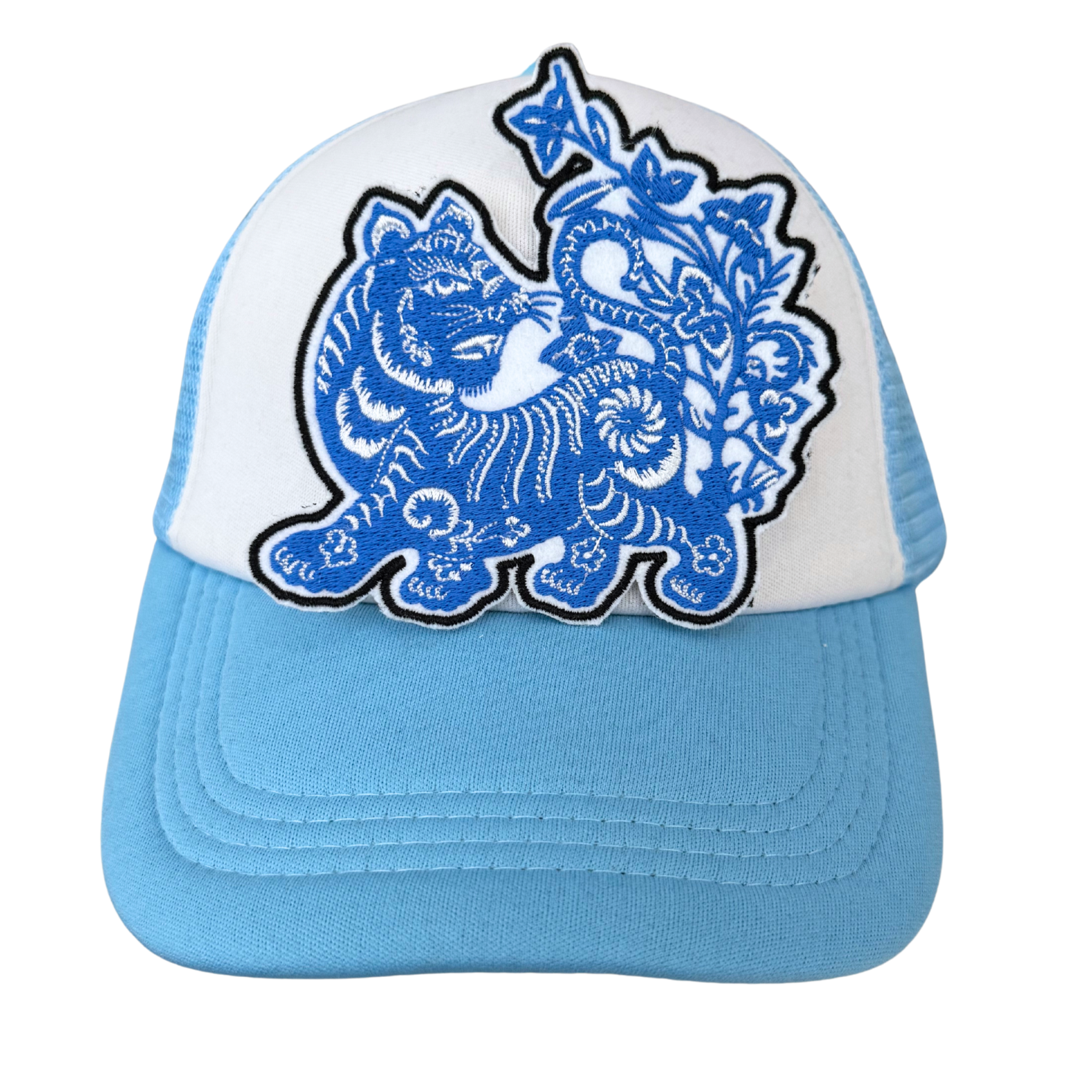 Blue embroidered tiger patch stylishly displayed on a blue and white trucker hat.