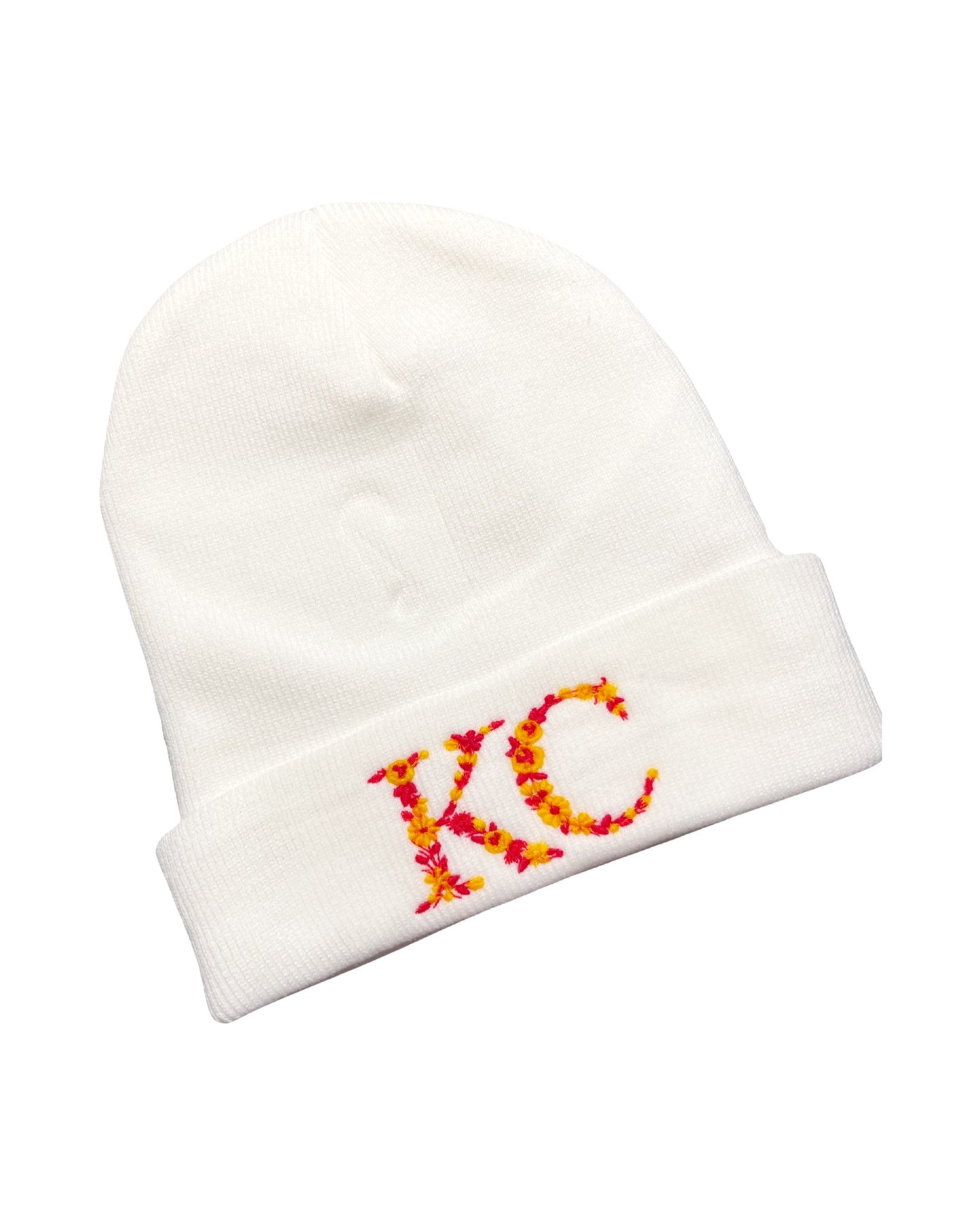 white acrylic beanie embroidered with the letters KC made of red and yellow kc chiefs colored flowers