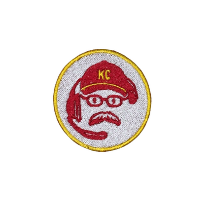Image of KC football coach patch featuring red cap, glasses, headset, and yellow KC letters
