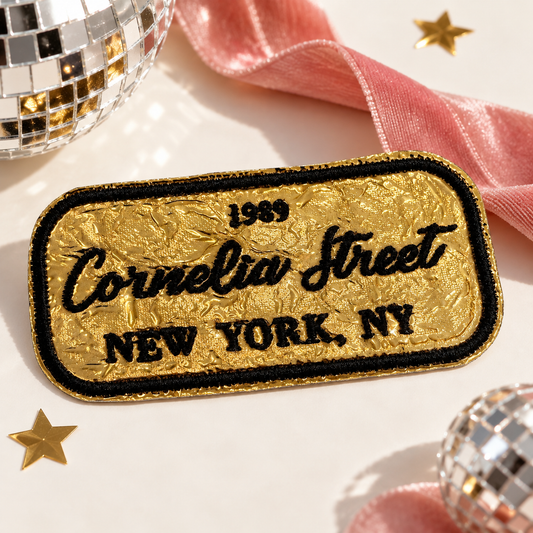 Cornelia Street gold and black embroidered iron-on patch styled with pink ribbon and disco ball accents