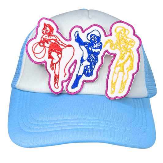 Vintage-style cowgirl trio patch on a white and blue trucker hat

