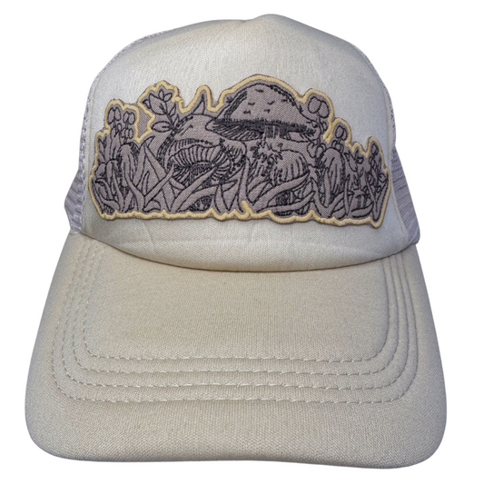 Front view of cream trucker hat with embroidered mushroom patch inspired by Pyrex Forest Fancies
