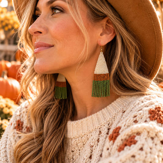 Cream and olive hand-beaded fringe earrings worn in autumn lifestyle photo