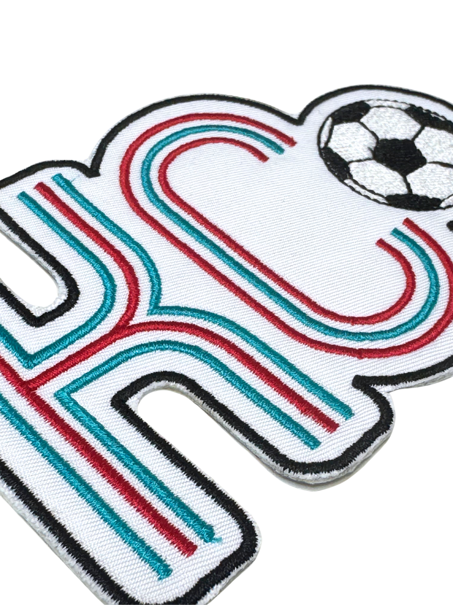 Close-up showing red and teal embroidery detail on KC soccer patch