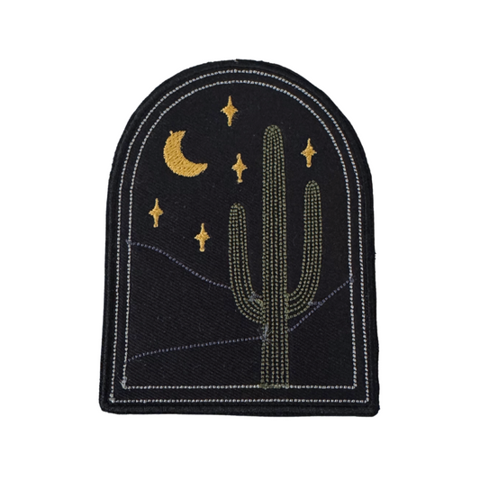 Embroidered patch with cactus, crescent moon, and stars on black background in arch shape
