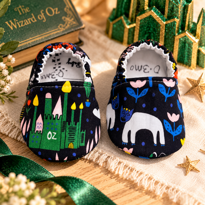 Emerald City wizard-inspired soft sole baby shoes, size 0–3 months, styled with green and gold storybook details