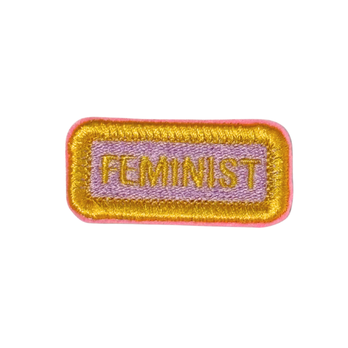"Embroidered rectangular patch with the word 'FEMINIST' in golden yellow on a soft lavender background with a pink and gold border."
