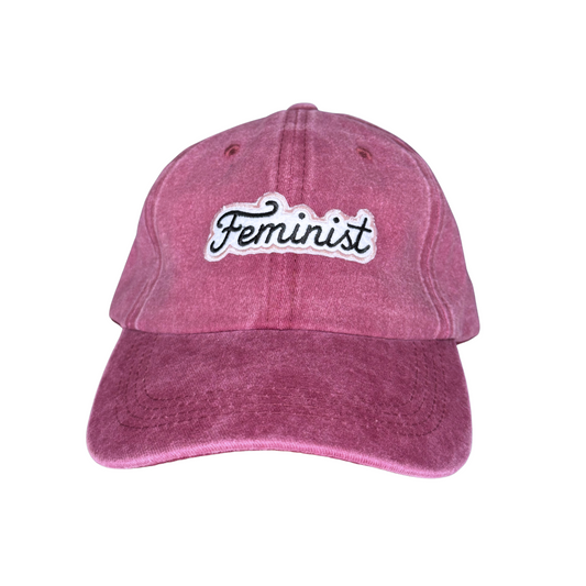 Pink cap with 'Feminist' text on a white background