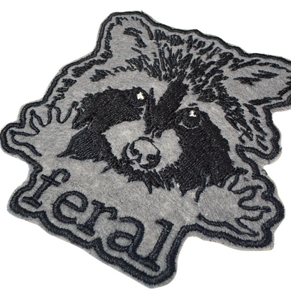 Close-up angled view of feral raccoon embroidered patch


