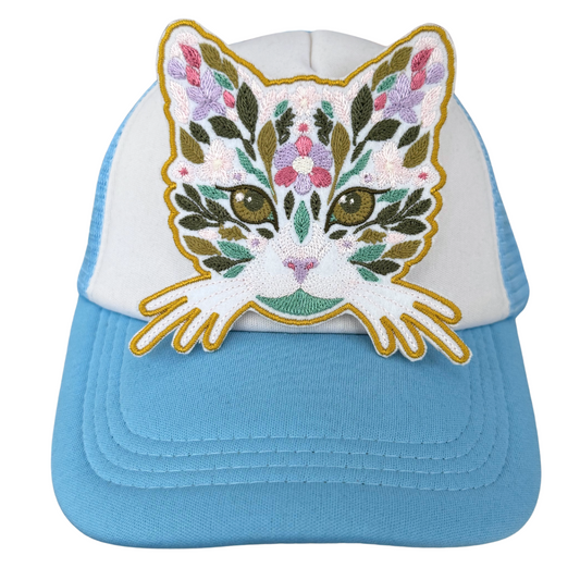 Floral cat face patch heat-pressed onto blue and white trucker hat
