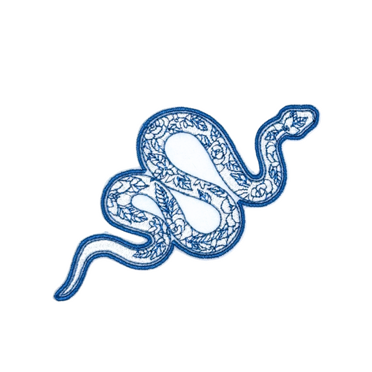 Close-up of a blue embroidered snake patch with floral detailing.
