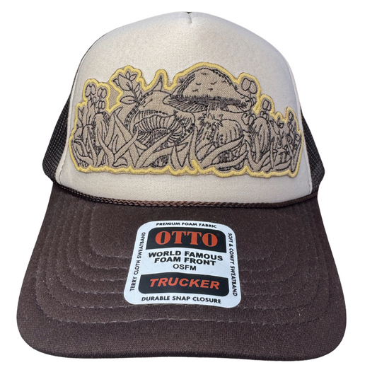 Front view of cream and brown trucker hat with embroidered mushroom patch inspired by vintage Pyrex Forest Fancies
