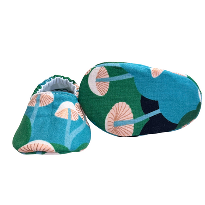 Bottom view of forest mushroom baby moccasins, highlighting the lightweight, vegan materials and soft soles designed for newborn foot development.