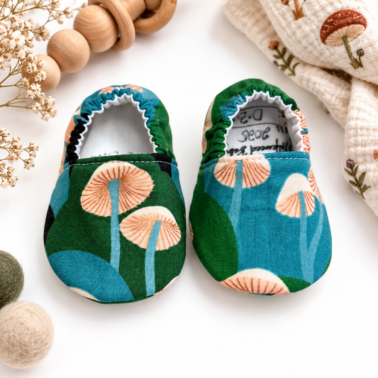 Forest mushroom baby moccasins styled hero photo