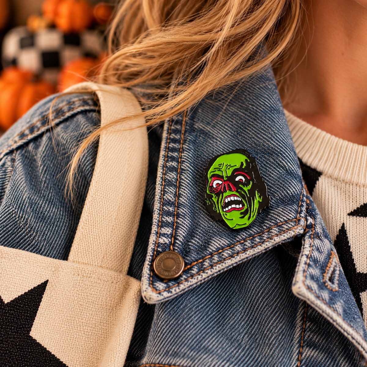 Green Frankenstein's monster enamel pin worn on a denim jacket