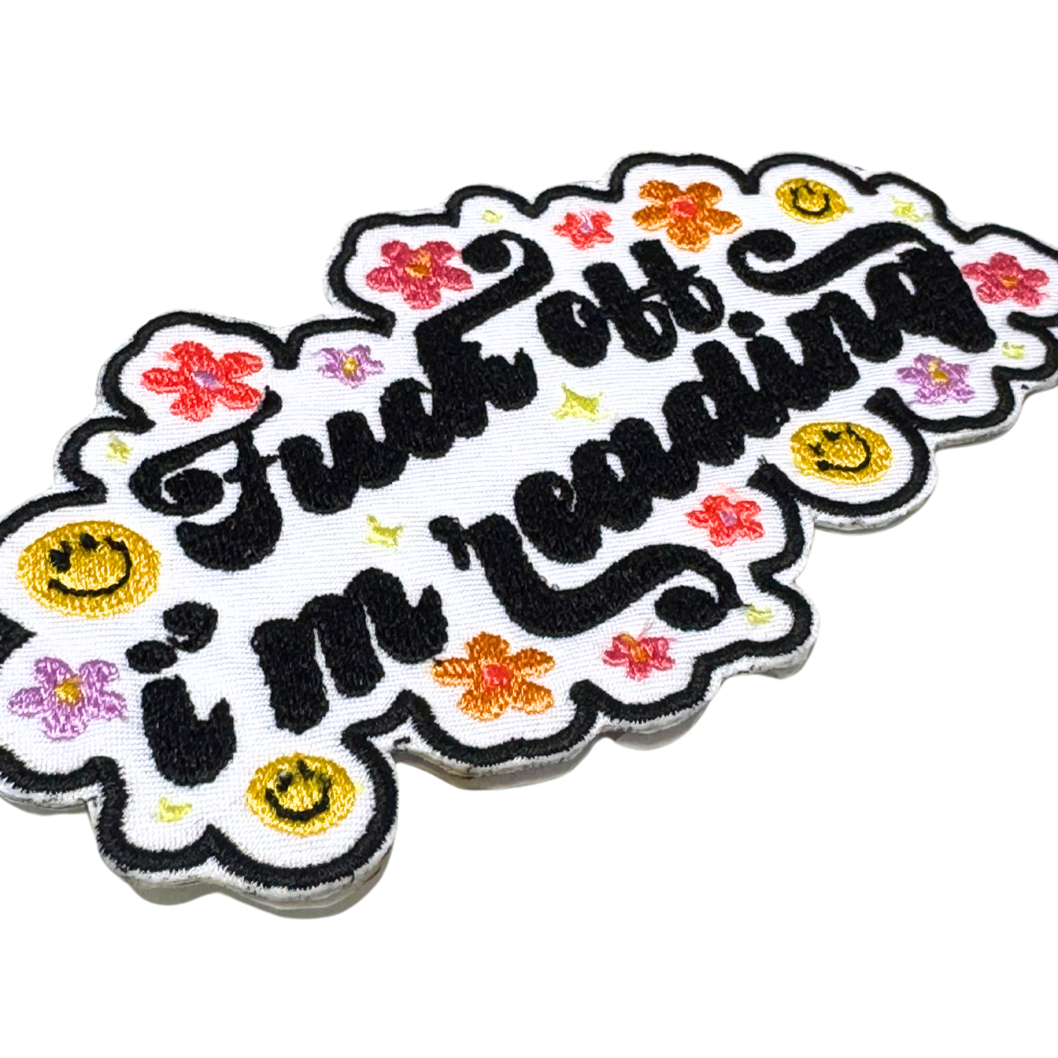 angled close-up of the colorful floral and smiley face patch